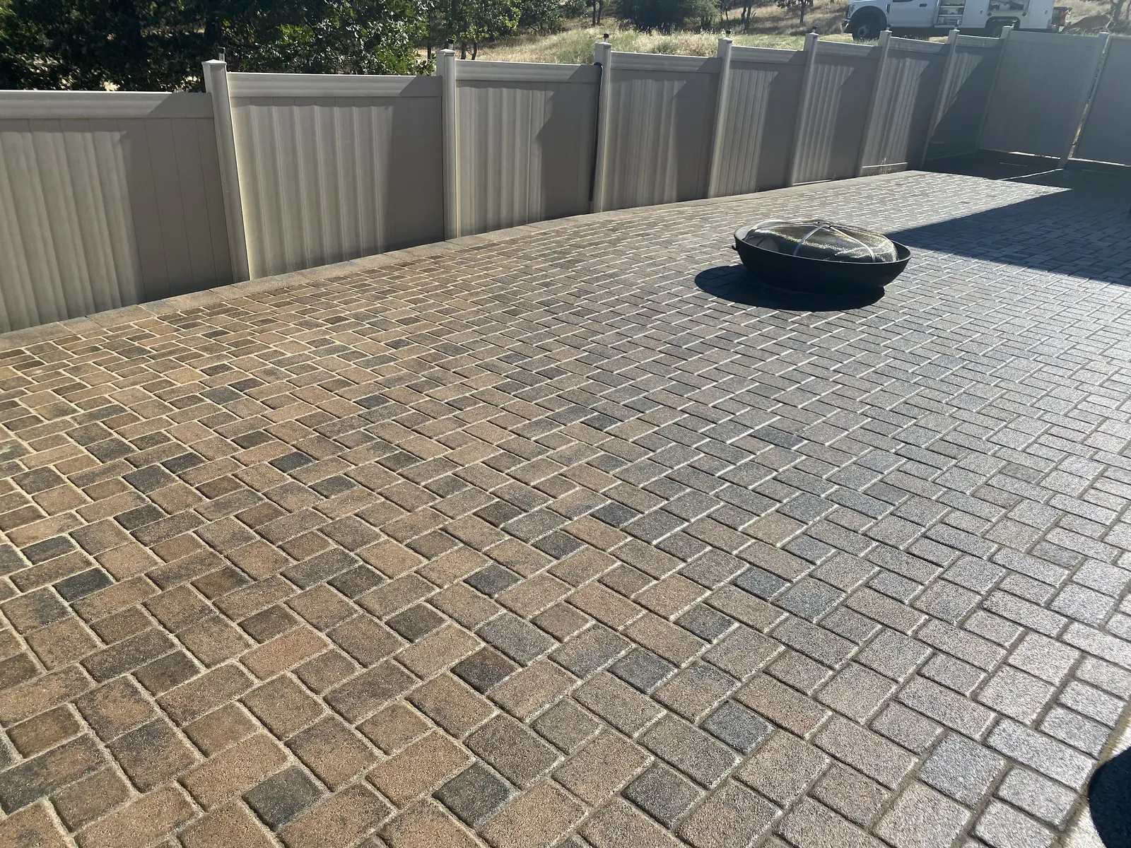 Large paver patio with a central fire pit