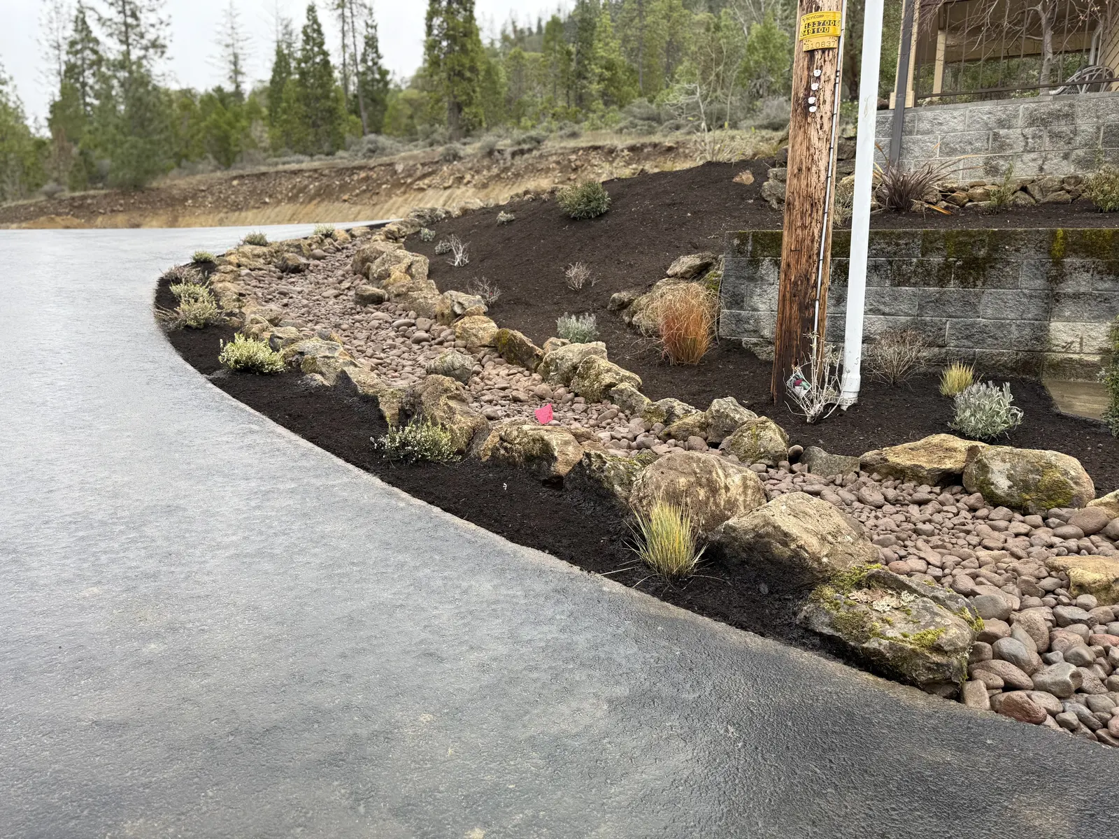 Curved landscape bed with rock border and new planting by Element