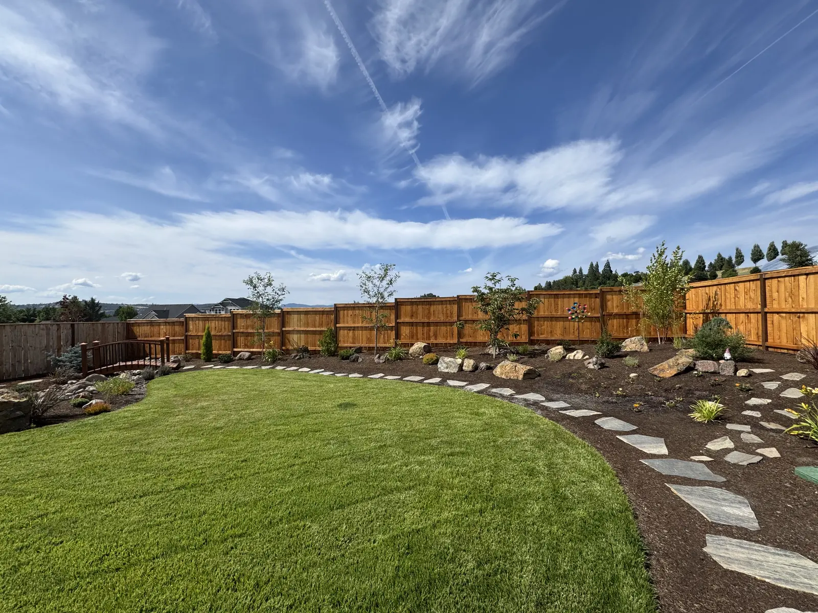 Finished lawn with rock-lined planting beds